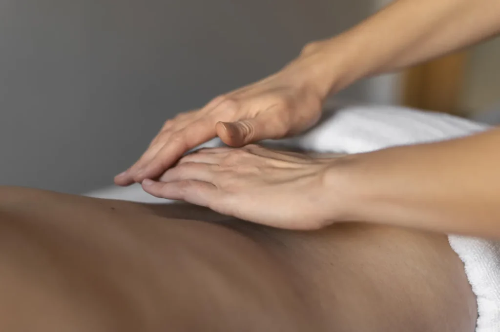 Masaz klasyczny - rece terapeuty podczas zabiegu relaksacyjnego
